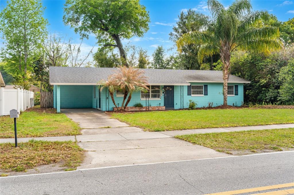 A single-story teal house with a carport, a concrete driveway, and a palm tree — 2923 CONWAY GARDENS ROAD, ORLANDO, FL