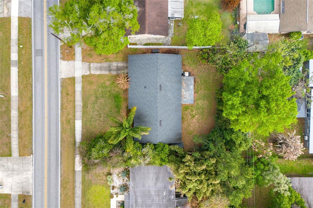 An aerial view shows a house with a dark roof surrounded by trees and grass — 2923 CONWAY GARDENS ROAD, ORLANDO, FL