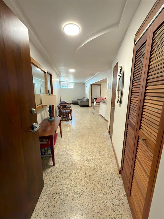 A hallway with terrazzo flooring leads to a living area with a sofa and chairs — 185 CALLE PINE GROVE UNIT B-1, CAROLINA, PR