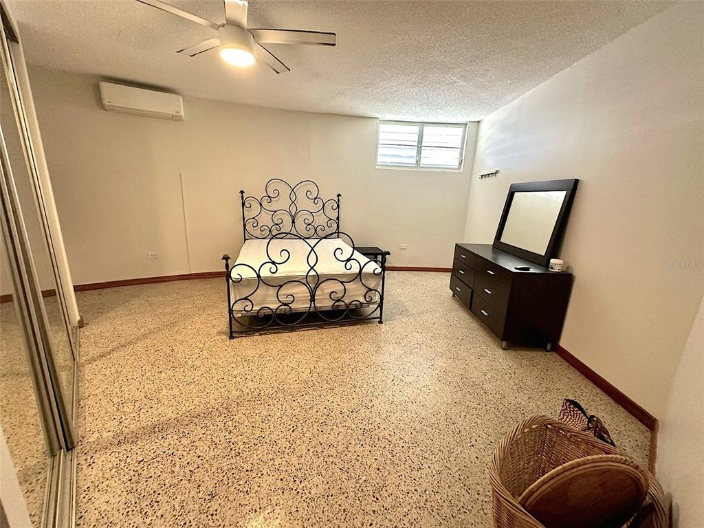 A bedroom with a metal bed frame, dark dresser, and speckled flooring — 185 CALLE PINE GROVE UNIT B-1, CAROLINA, PR