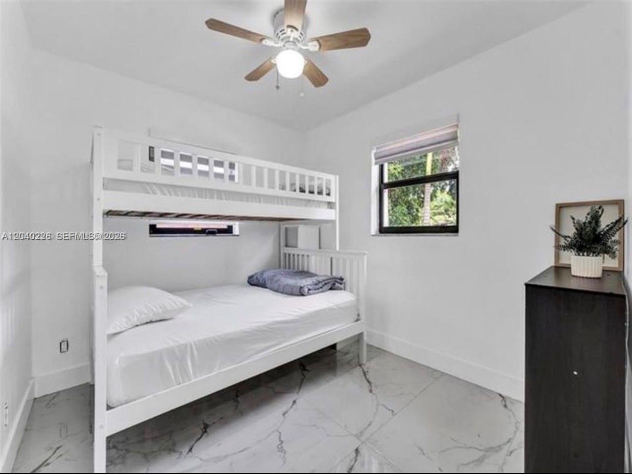 A bedroom features a white bunk bed, marble-patterned tile flooring, and a ceiling fan — 2730 NE 16th ave, Pompano Beach FL 33064, POMPANO BEACH, FL