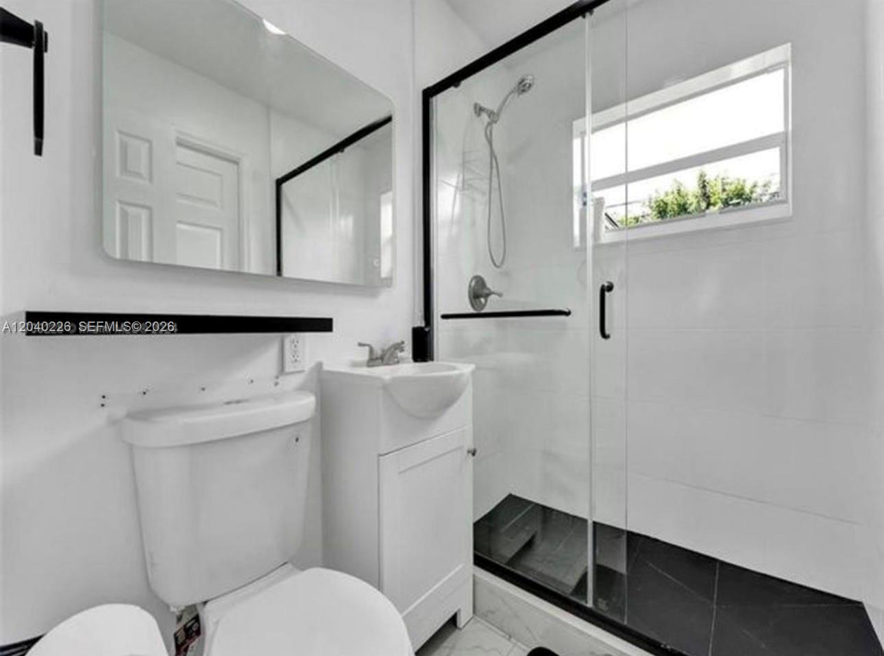A small bathroom features a white toilet, a pedestal sink, and a glass-enclosed shower — 2730 NE 16th ave, Pompano Beach FL 33064, POMPANO BEACH, FL