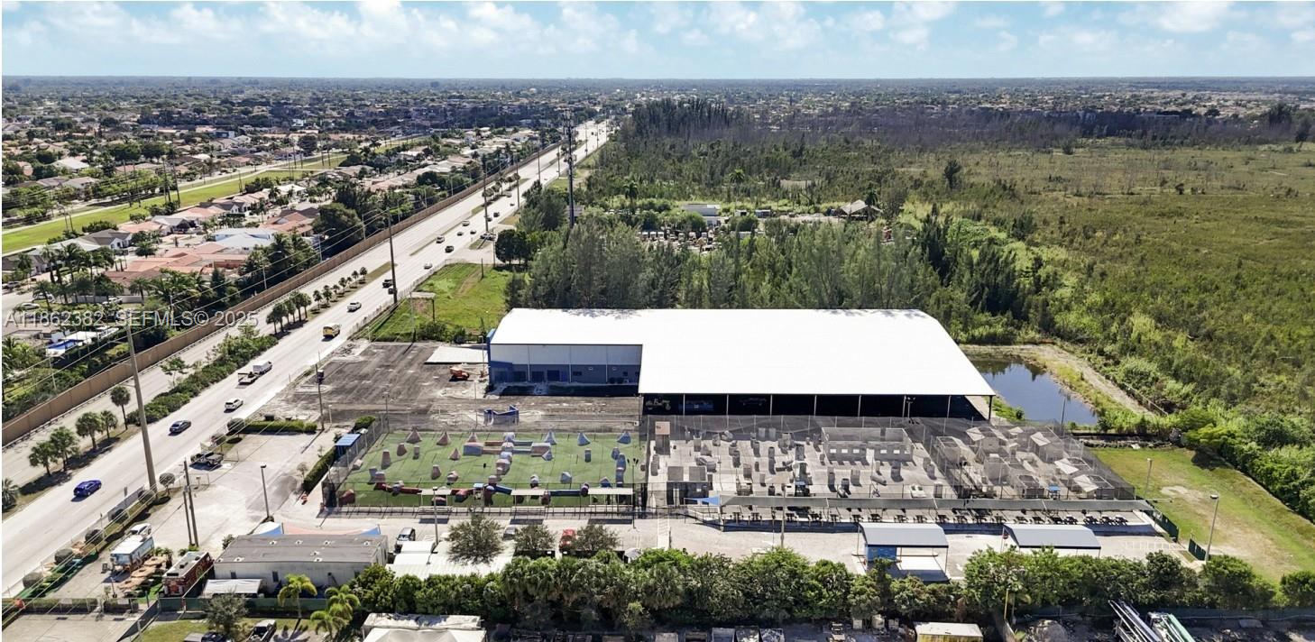 An aerial view shows a large warehouse building with an adjacent outdoor paintball course — 220 NW 137th Ave, Miami FL 33182, MIAMI, FL