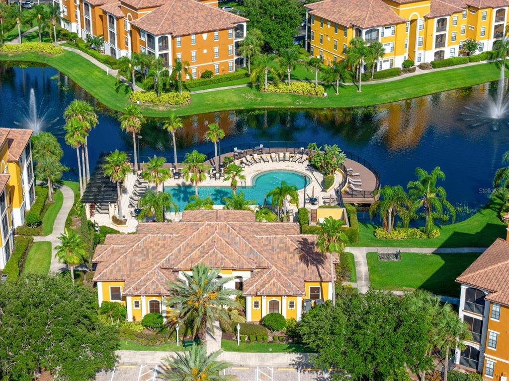 An aerial view shows a community clubhouse with a swimming pool surrounded by apartment buildings — 8377 38TH STREET CIRCLE E UNIT 106, SARASOTA, FL