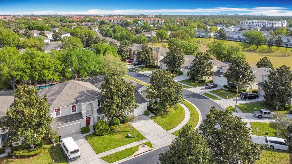 An aerial view shows a two-story suburban house with a driveway and surrounding neighborhood — 7788 BASNETT CIRCLE, KISSIMMEE, FL