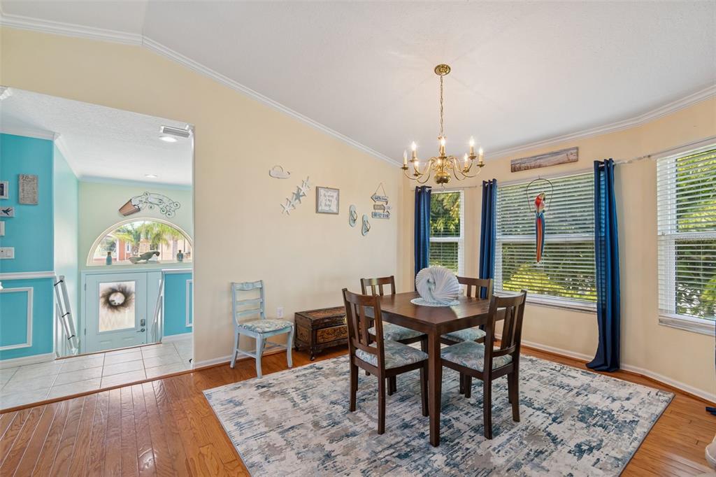 A dining room with a wooden table, chairs, area rug, and a chandelier — 6170 SEASIDE DRIVE, NEW PORT RICHEY, FL