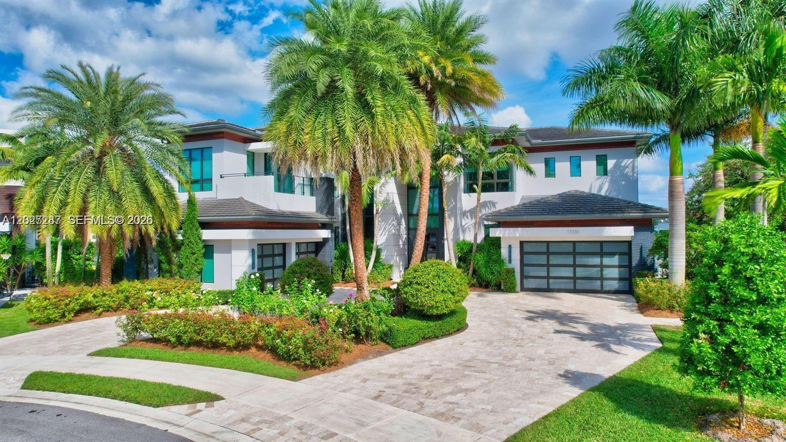 A two-story modern house with a paved driveway, palm trees, and two garage doors — 17230 Brulee Breeze Way, Boca Raton FL 33496, BOCA RATON, FL