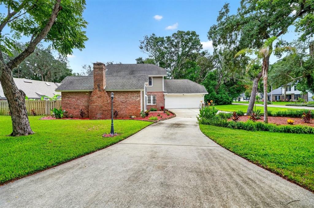 A brick house with a concrete driveway, a chimney, and a two-car garage — 1 EAGLE ROCK TRAIL, ORMOND BEACH, FL