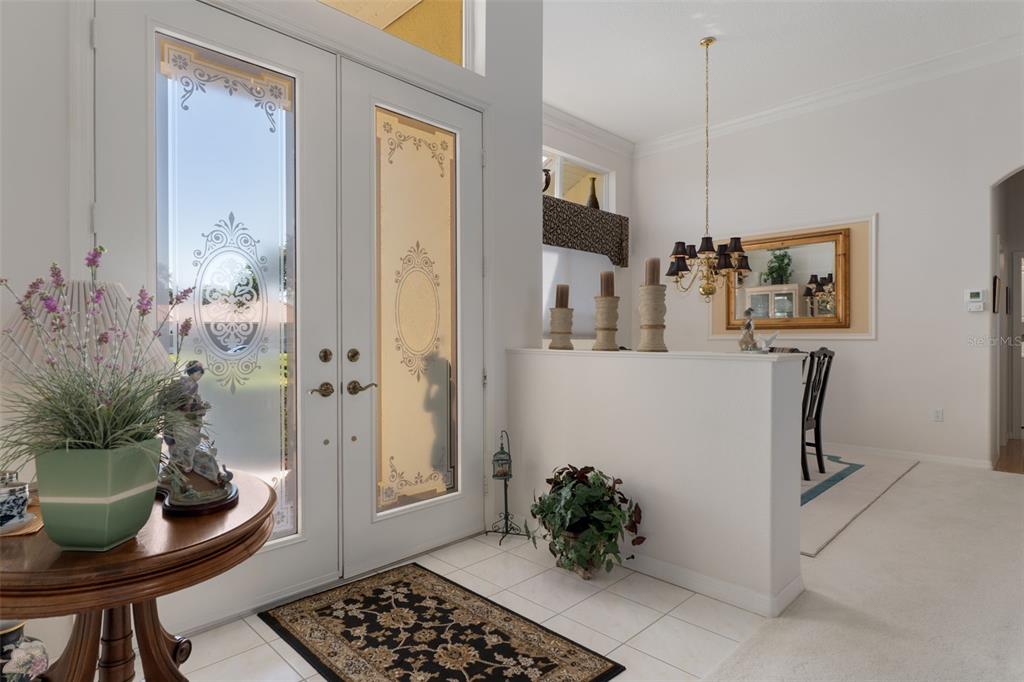 An entryway features double glass-paneled doors, a round wooden table, and a half-wall partition — 10081 GEORGETOWN COURT, WEEKI WACHEE, FL