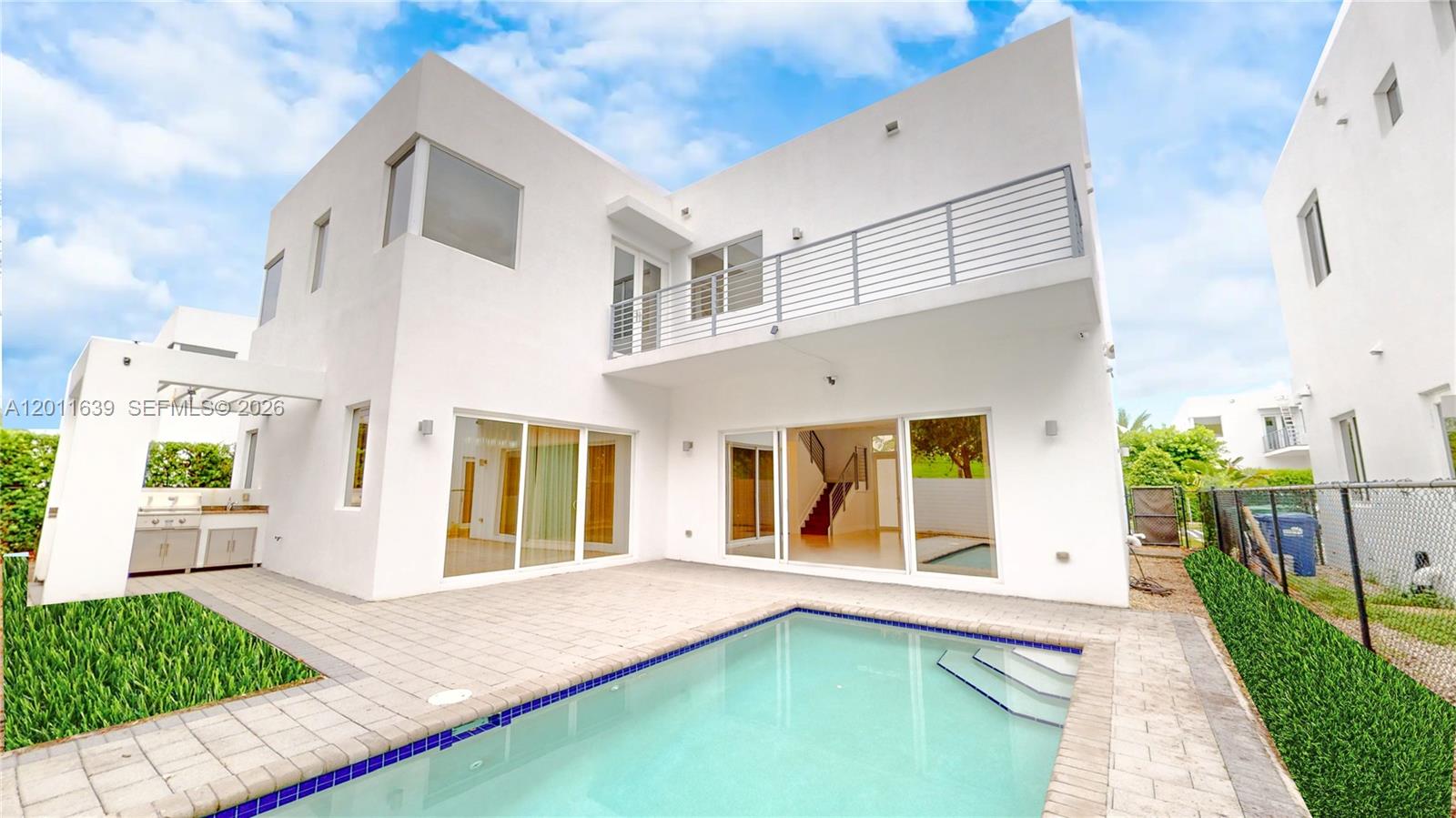 The exterior of a modern white two-story house features a swimming pool and patio — 9980 NW 74th Ter, Doral FL 33178, DORAL, FL