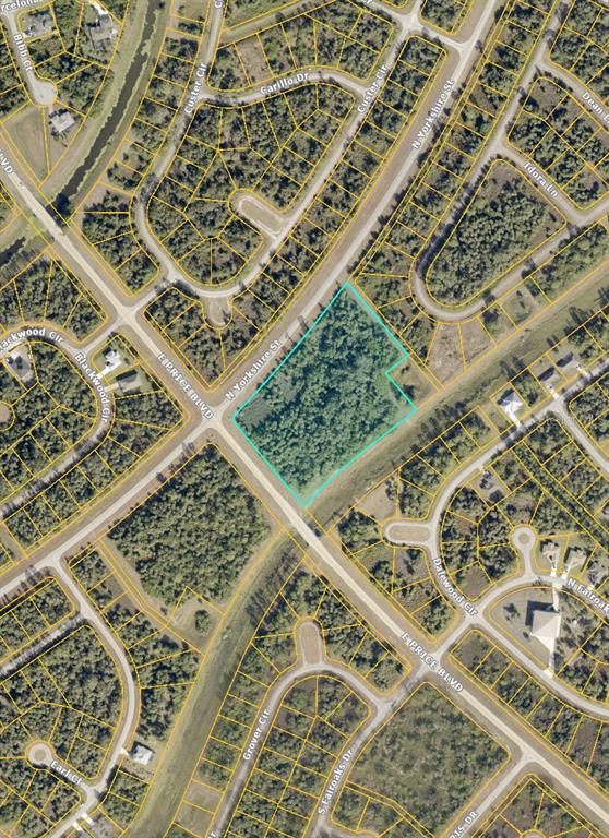 This is an aerial map showing a vacant, wooded lot outlined in light blue — N YORKSHIRE STREET, NORTH PORT, FL