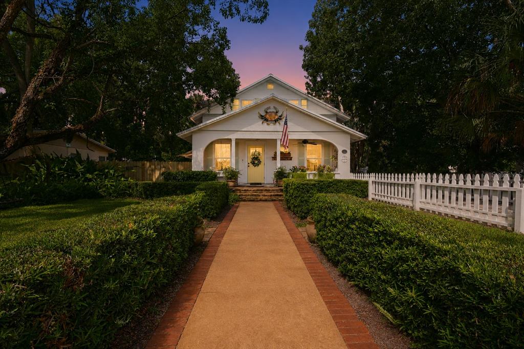 A white house with a yellow front door and a crab decoration above the porch — 1112 PALMETTO STREET, NEW SMYRNA BEACH, FL