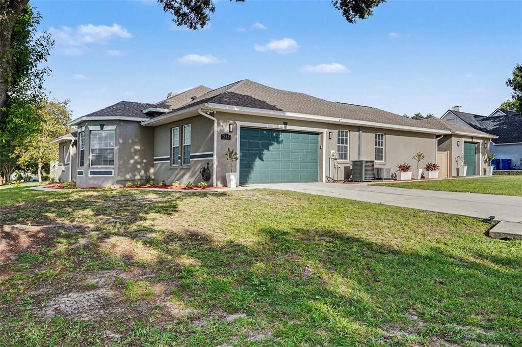 A single-story house with a green garage door, gray siding, and a concrete driveway — 265 BAYBERRY DRIVE, POLK CITY, FL