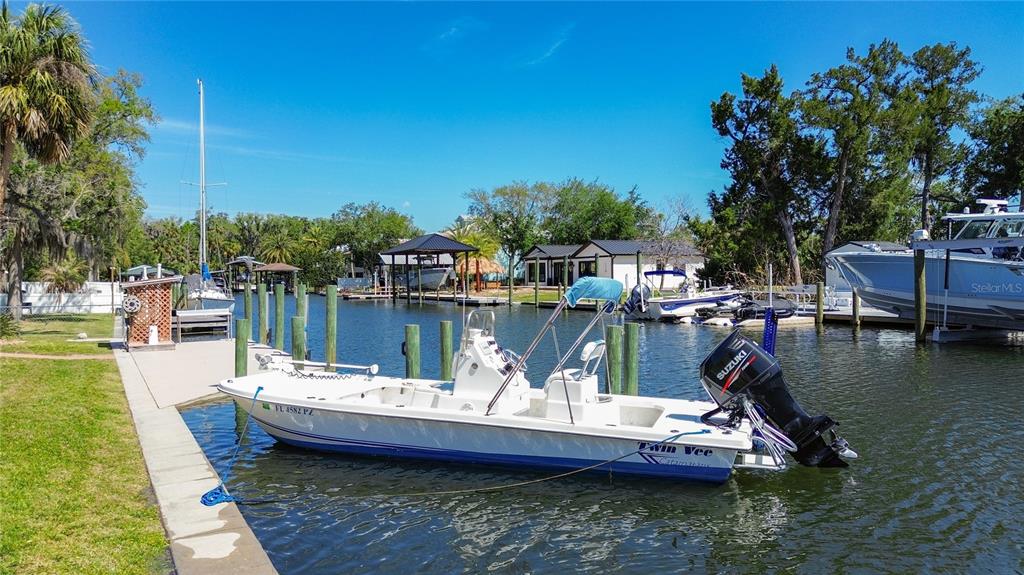 A white Twin Vee boat is docked at a canal next to a grassy yard — 1920 NW 16TH STREET, CRYSTAL RIVER, FL