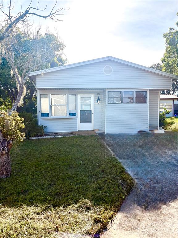 A single-story house with light blue siding, a front door, and a concrete driveway — 22 WOODRUFF WAY, LAKE WALES, FL