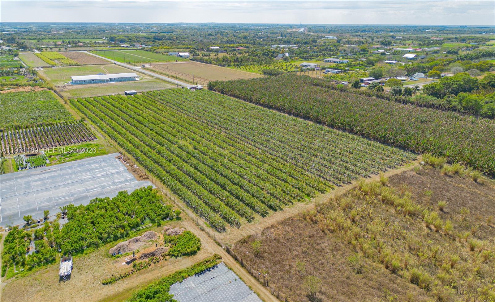 An aerial view shows a large agricultural field with rows of crops and nearby structures — 139XX sw 180TH AVE, Miami FL 33196, MIAMI, FL
