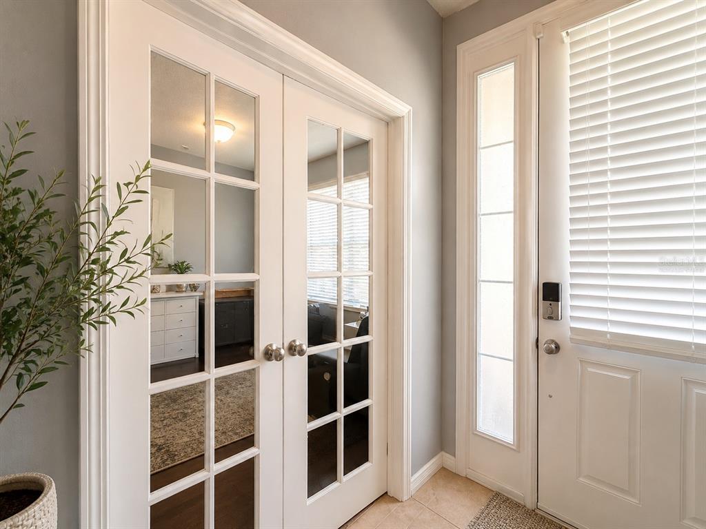 A white double French door and a front door with a sidelight in an entryway — 5169 DOVE TREE STREET, ORLANDO, FL