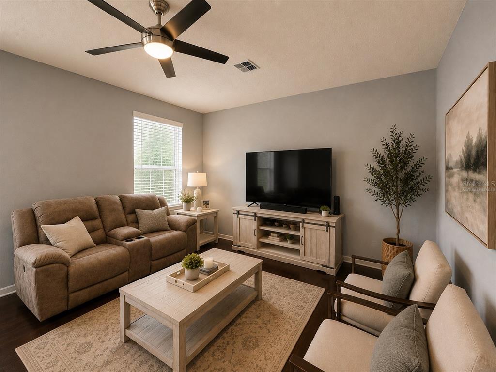 A living room features a brown sofa, two armchairs, a coffee table, and a television console — 5169 DOVE TREE STREET, ORLANDO, FL
