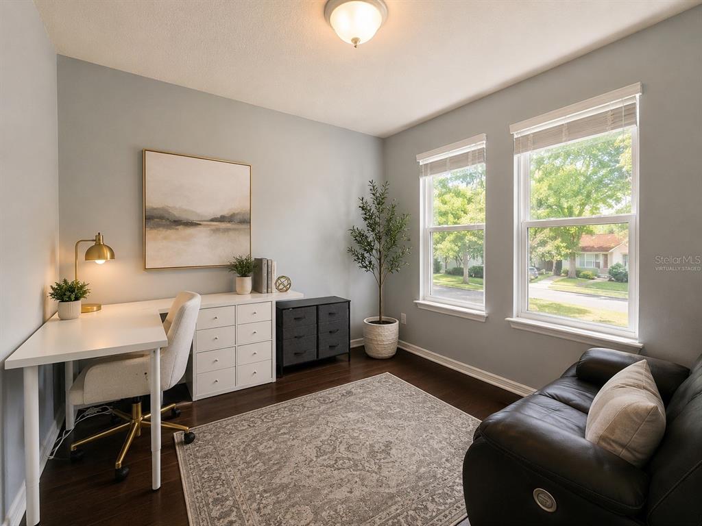 A home office features a white desk, a black cabinet, and a dark leather sofa — 5169 DOVE TREE STREET, ORLANDO, FL