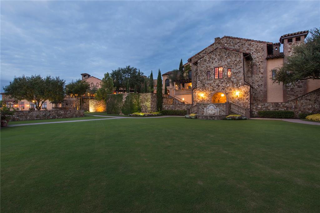 A large stone estate features a sprawling lawn, a stone fountain, and multi-level terraces — 16238 RAVENNA COURT, BELLA COLLINA, FL