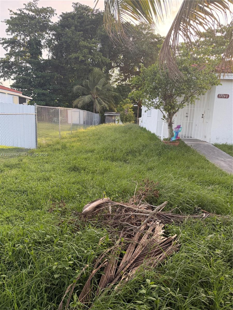 A white house with a metal security door stands beside a large, overgrown grassy yard — 17740 SW 103rd Ave # 0, Miami FL 33157, MIAMI, FL