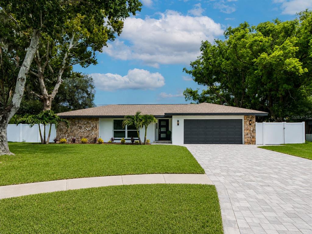 A screened-in patio features a swimming pool, wicker furniture, and a white vinyl fence — 1967 CASTILLE DRIVE, DUNEDIN, FL