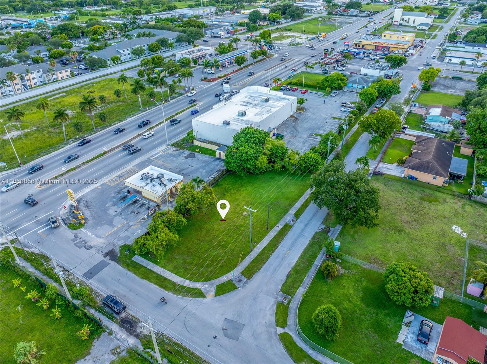 An aerial view shows a vacant grassy lot adjacent to a commercial building and road — 21 ave, Miami FL 33147, MIAMI, FL