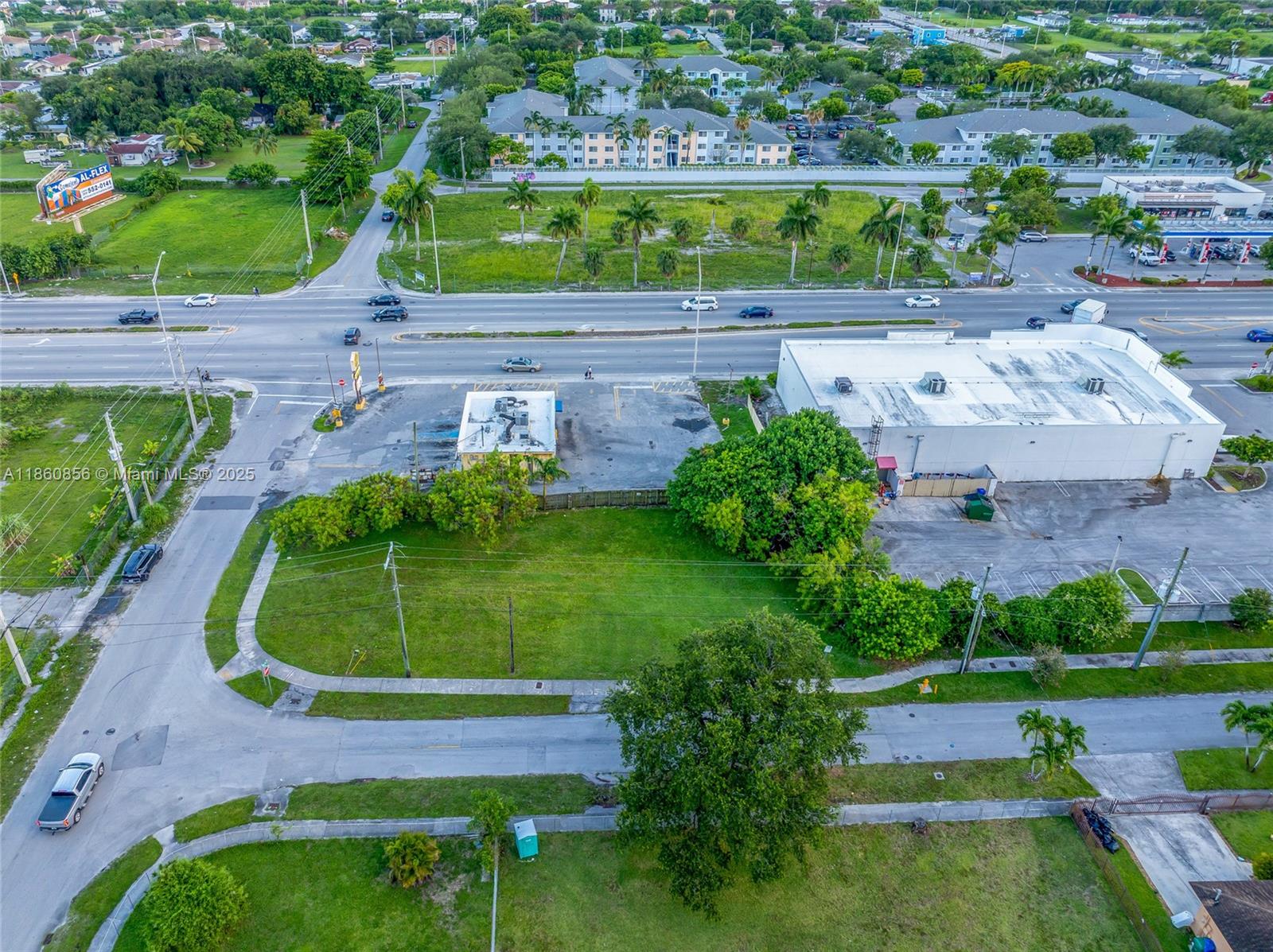 An aerial view shows a vacant grassy lot adjacent to a commercial building and road — 21 ave, Miami FL 33147, MIAMI, FL