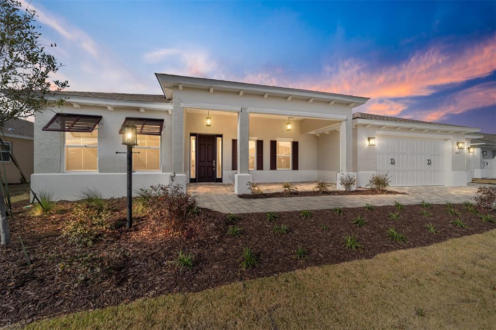 A single-story house with a white stucco exterior, a covered entryway, and a two-car garage — 10071 SW 82ND PLACE ROAD, OCALA, FL