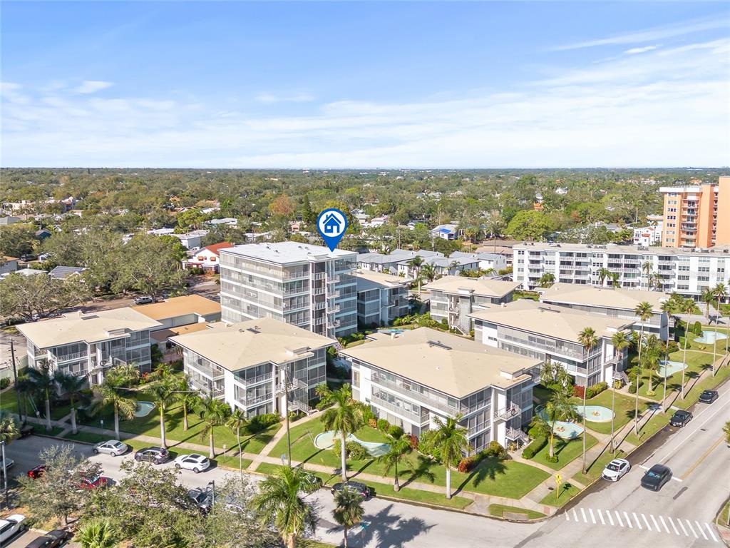 An aerial view shows several multi-story apartment buildings surrounded by palm trees and parking lots — 1012 N SHORE DRIVE NE UNIT 14, ST PETERSBURG, FL