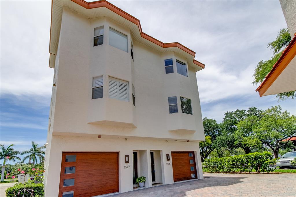A three-story stucco building features two garage doors and two separate entrances — 1575 PINELLAS BAYWAY WAY S UNIT 1575, TIERRA VERDE, FL