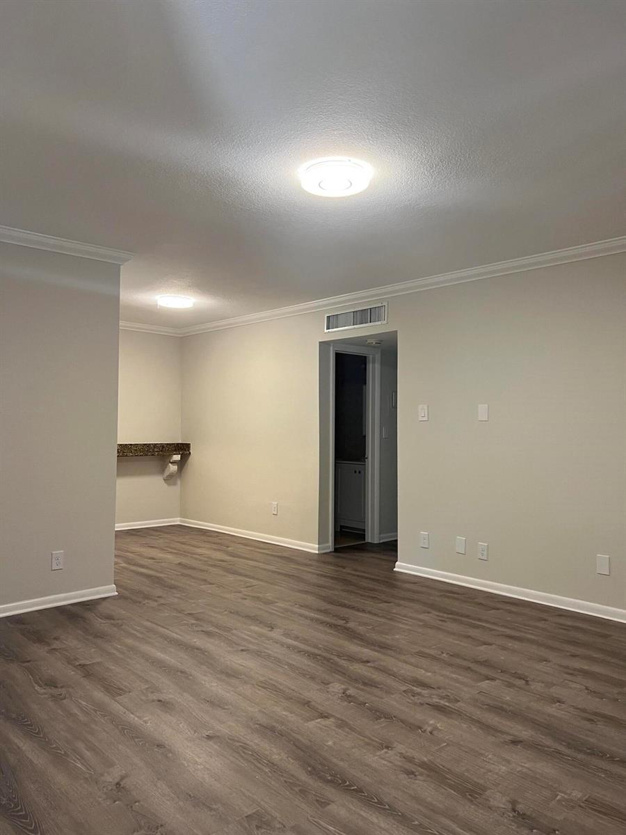 An empty room features light-colored walls, wood-look flooring, a ceiling light, and a small alcove — 3550 NW 8th Avenue # 808, Pompano Beach FL 33064, POMPANO BEACH, FL
