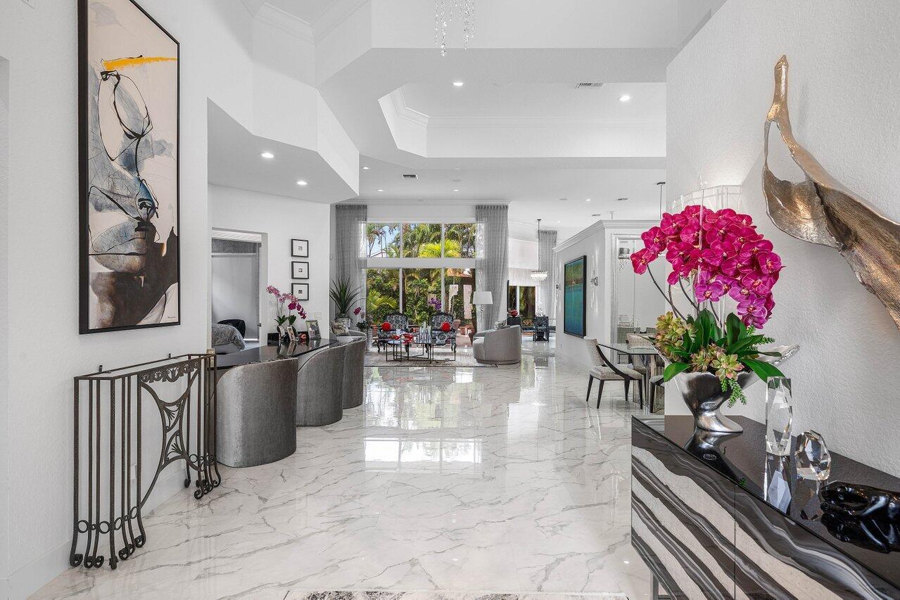A bright, open-concept foyer with white marble floors leads to a living area with windows — 6517 Somerset Circle, Boca Raton FL 33496, BOCA RATON, FL
