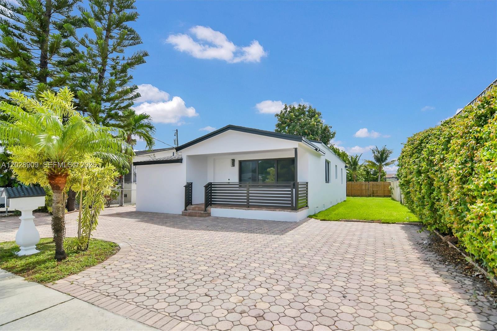 A white single-story house features a paved driveway, a front porch, and a green lawn — 85 SW 30th Ave, Miami FL 33135, MIAMI, FL