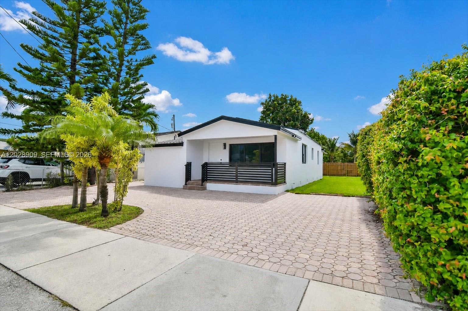 A white single-story house features a paved driveway, a small front porch, and landscaping — 85 SW 30th Ave, Miami FL 33135, MIAMI, FL