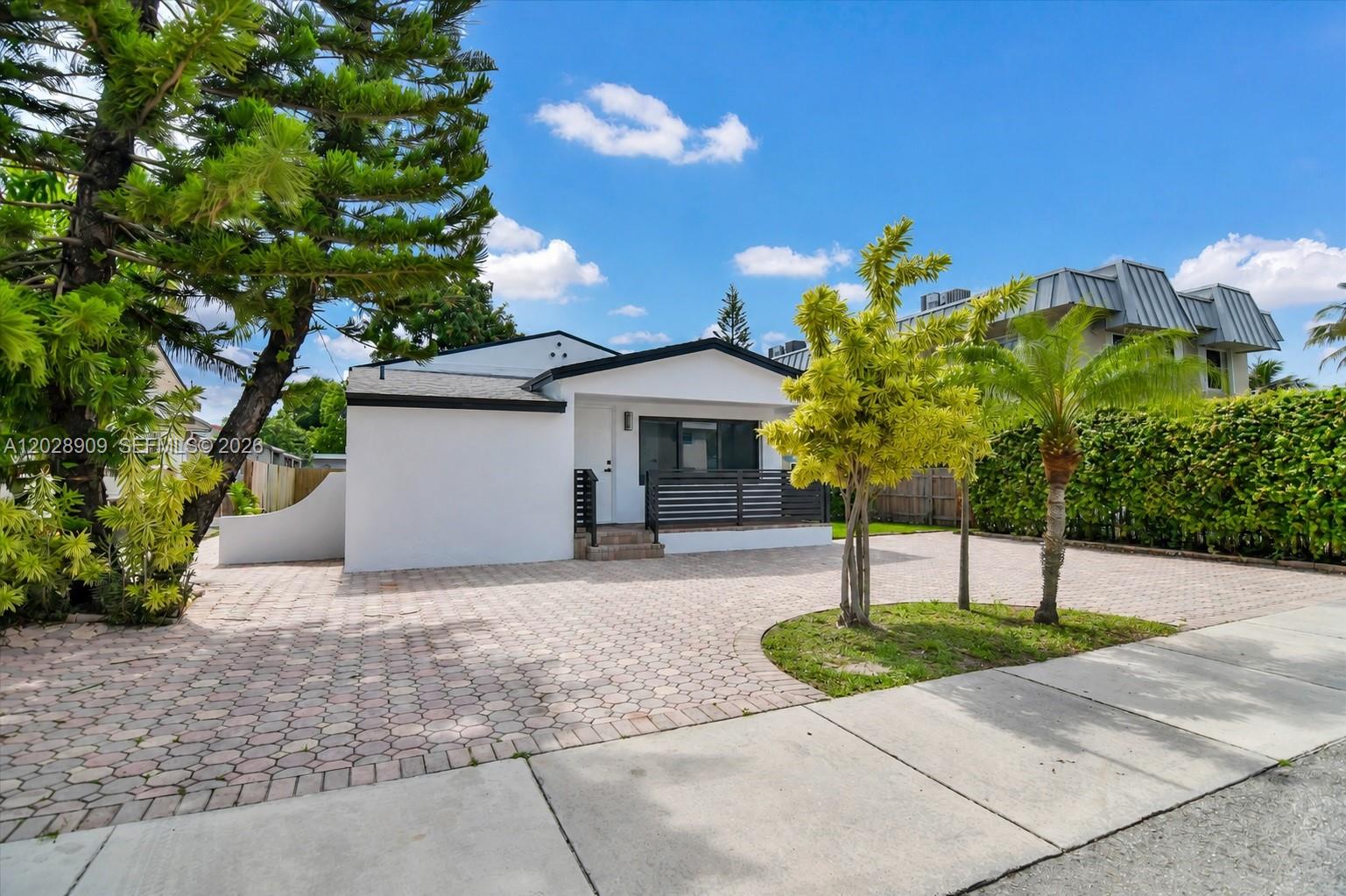 A white single-story house features a paved driveway, a small front porch, and landscaping — 85 SW 30th Ave, Miami FL 33135, MIAMI, FL