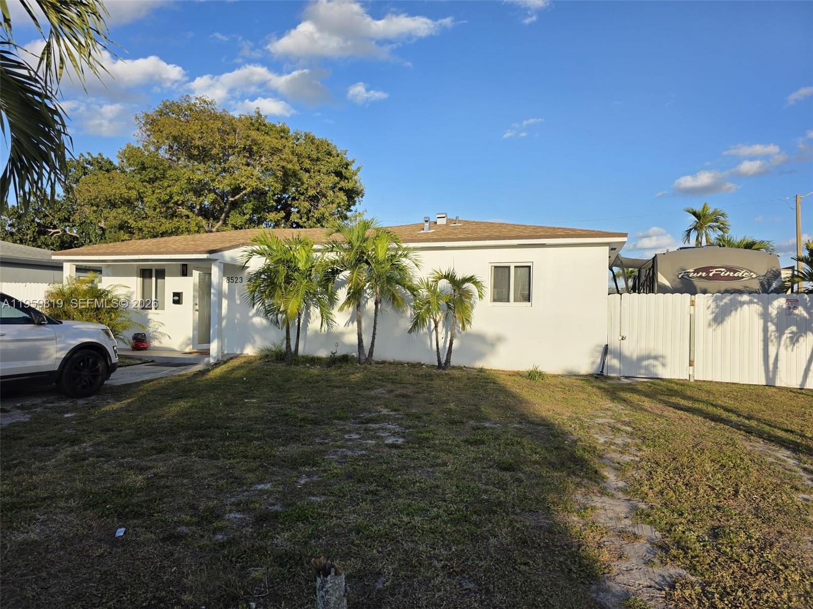 A white single-story house features a front yard, palm trees, and a parked recreational vehicle — 8523 NW 35th Pl, Miami FL 33147, MIAMI, FL