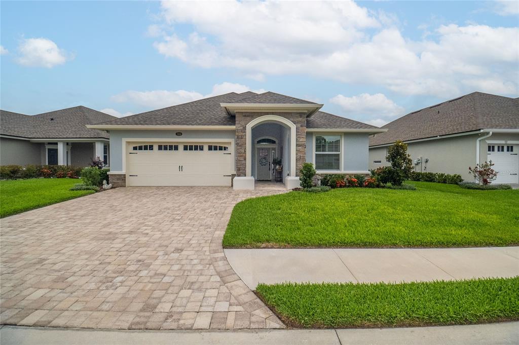 A single-story house with a stone-accented entryway, a paved driveway, and a two-car garage — 7914 LAKE JAMES BOULEVARD, LAKELAND, FL