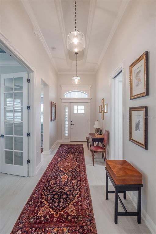 A bright entryway features a long patterned rug, two pendant lights, and a white door — 7914 LAKE JAMES BOULEVARD, LAKELAND, FL