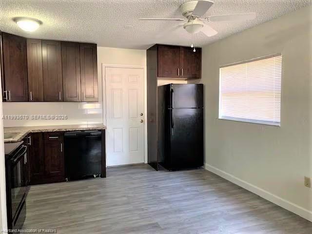 A kitchen features dark wood cabinets, black appliances, and light-colored wood-look flooring — 425 Las Palmas # 612, Avon Park FL 33825, AVON PARK, FL