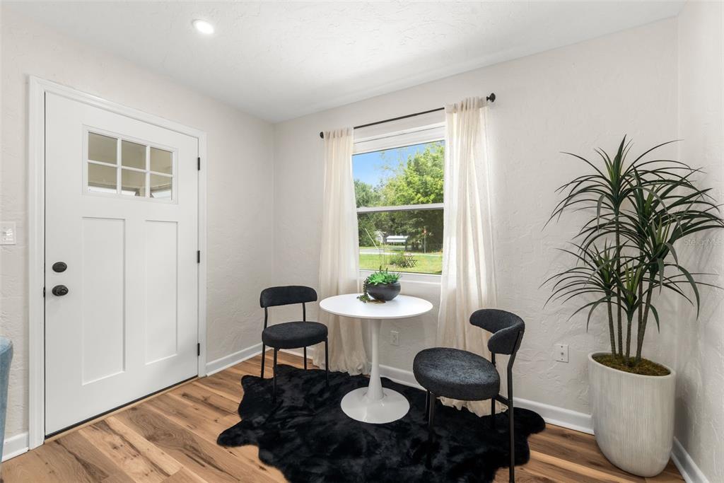 A small dining nook features a white pedestal table, two chairs, and a black rug — 807 NW 24TH AVENUE, GAINESVILLE, FL