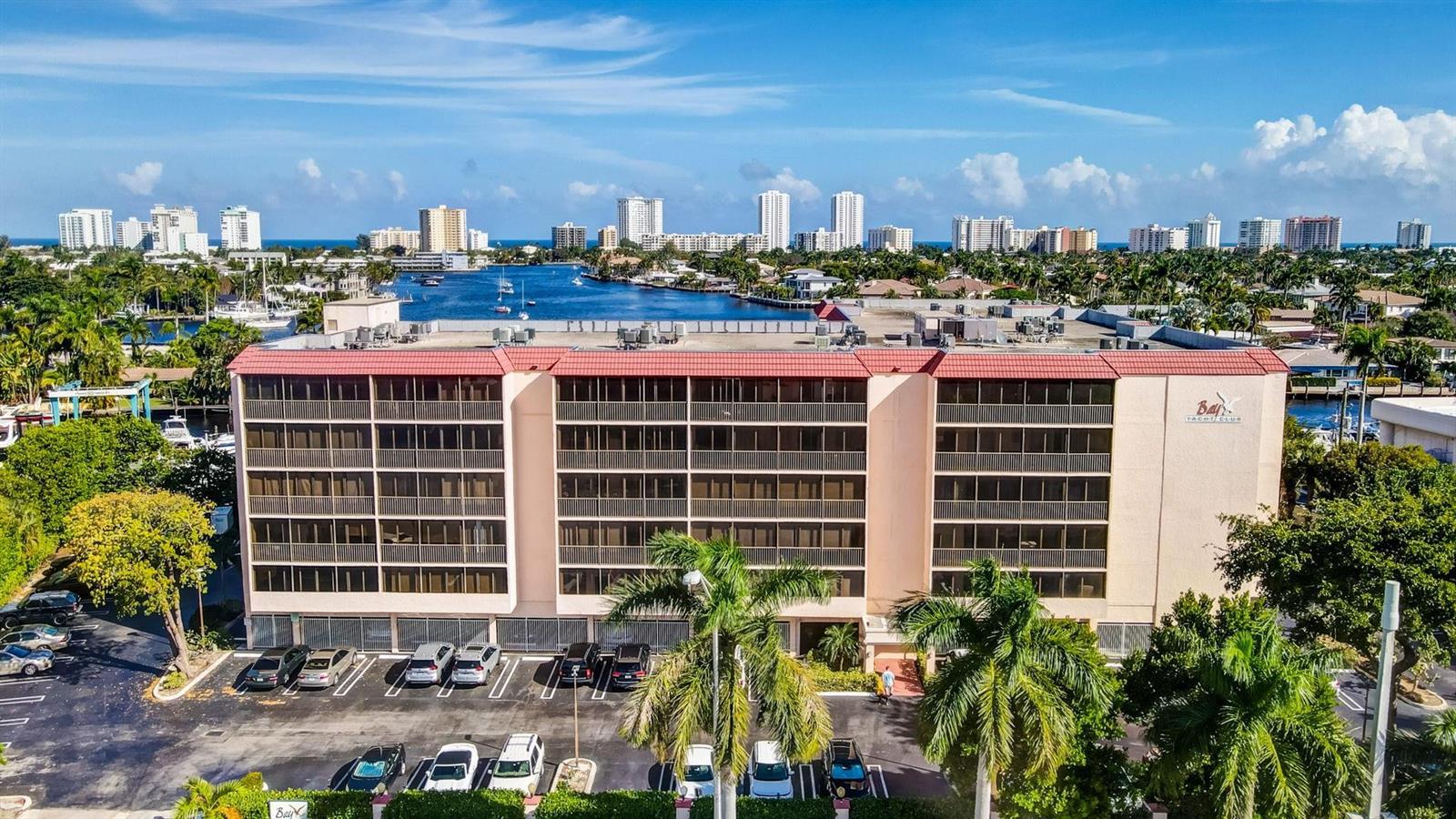 An aerial view shows a multi-story apartment building with a parking lot and palm trees — 740 S Federal Highway # 202, Pompano Beach FL 33062, POMPANO BEACH, FL