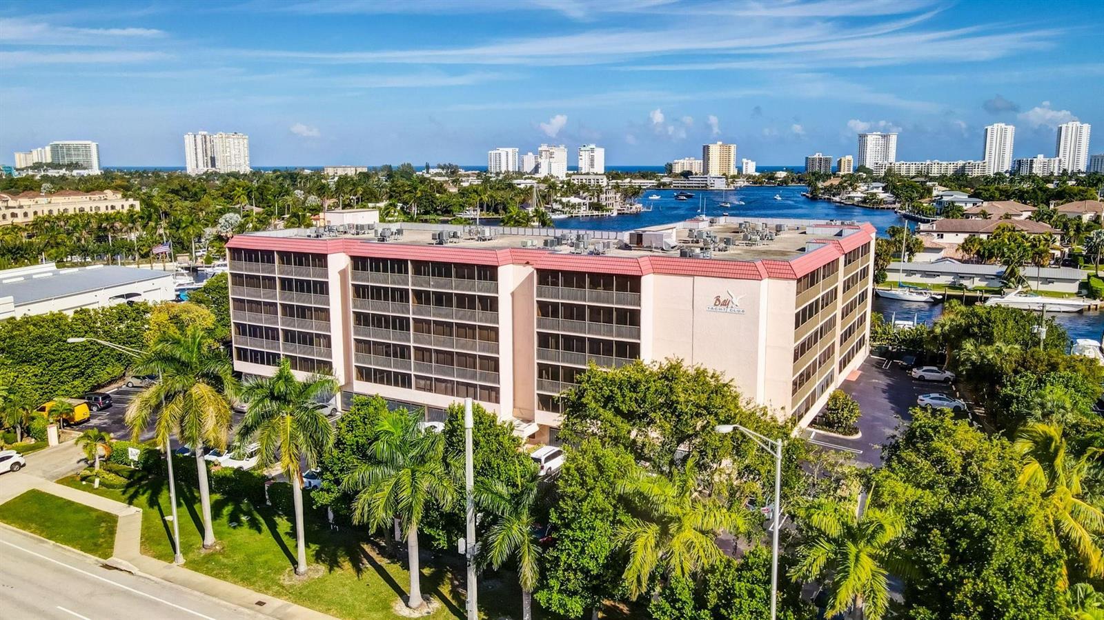 An aerial view shows a multi-story apartment building with a red roof near a waterway — 740 S Federal Highway # 202, Pompano Beach FL 33062, POMPANO BEACH, FL