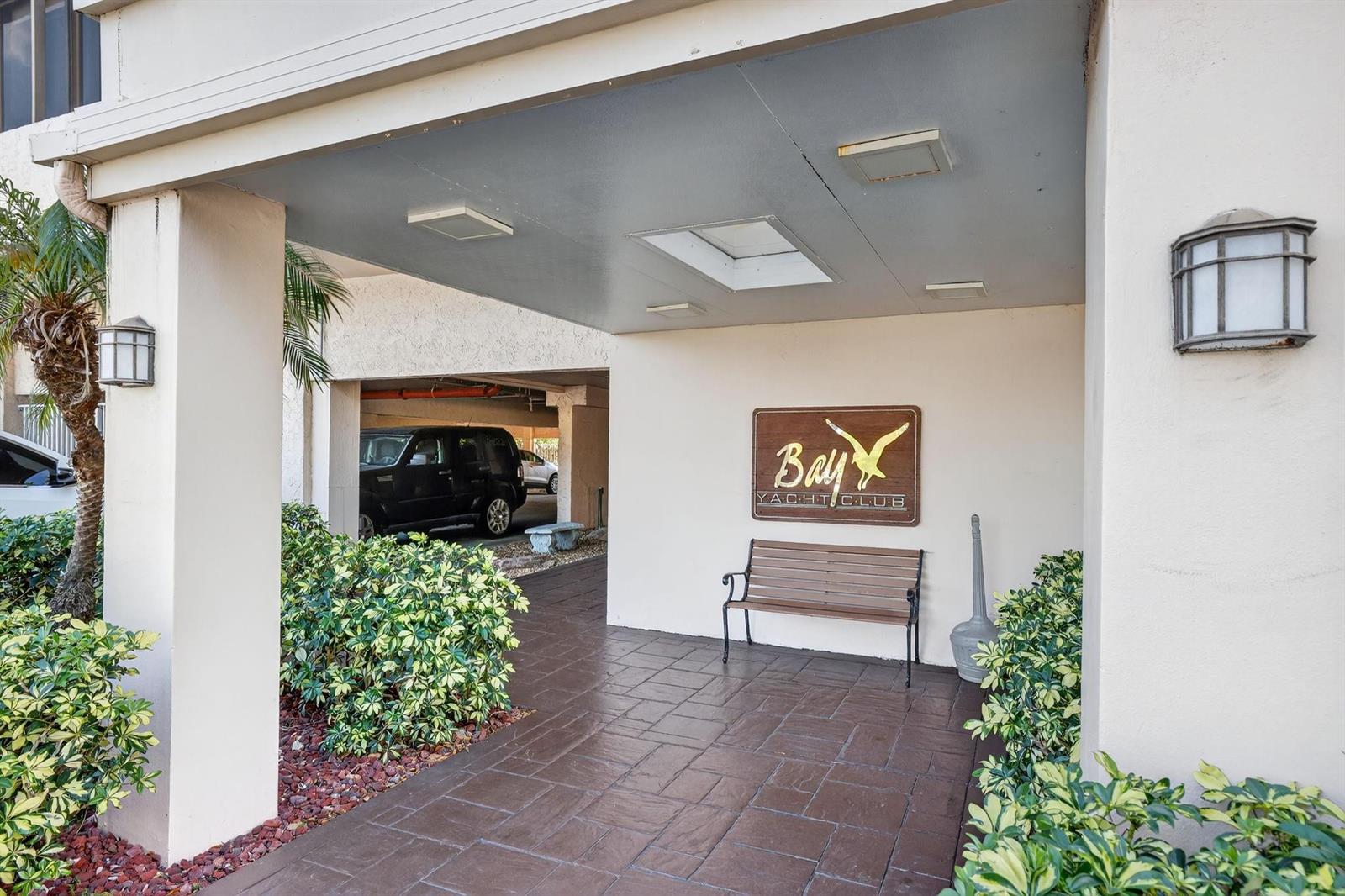 A covered entrance features a wooden bench, a sign, and a paved walkway — 740 S Federal Highway # 202, Pompano Beach FL 33062, POMPANO BEACH, FL