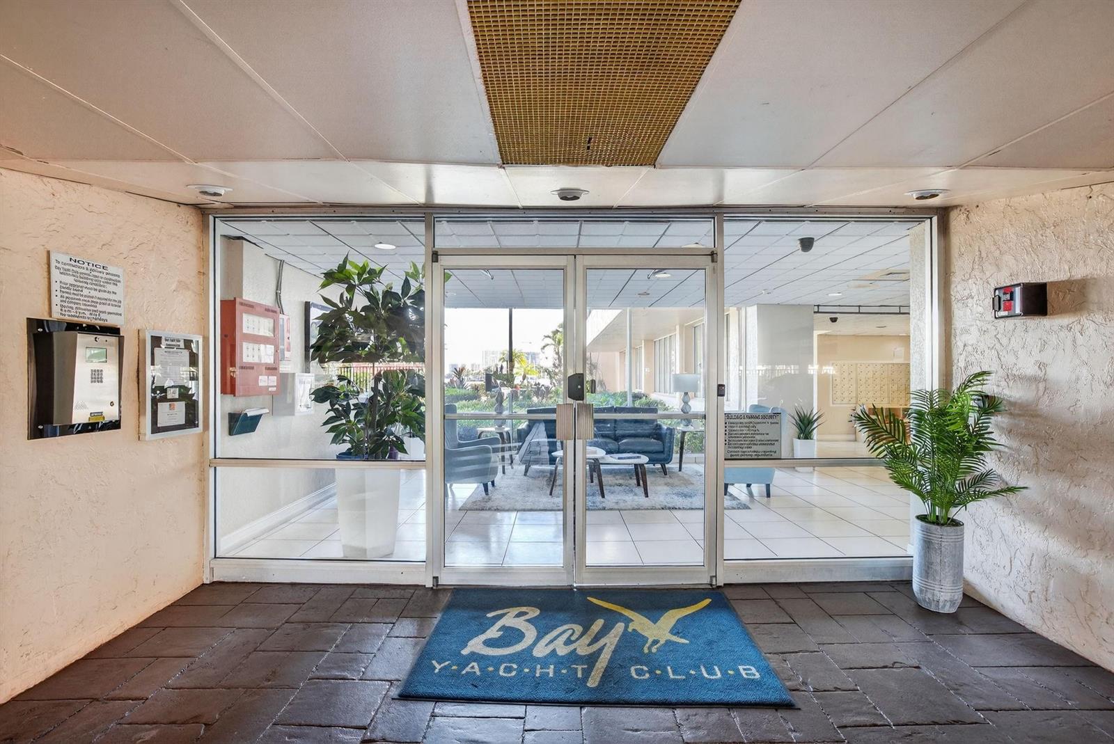 The entrance to the Bay Yacht Club features glass double doors and a branded mat — 740 S Federal Highway # 202, Pompano Beach FL 33062, POMPANO BEACH, FL