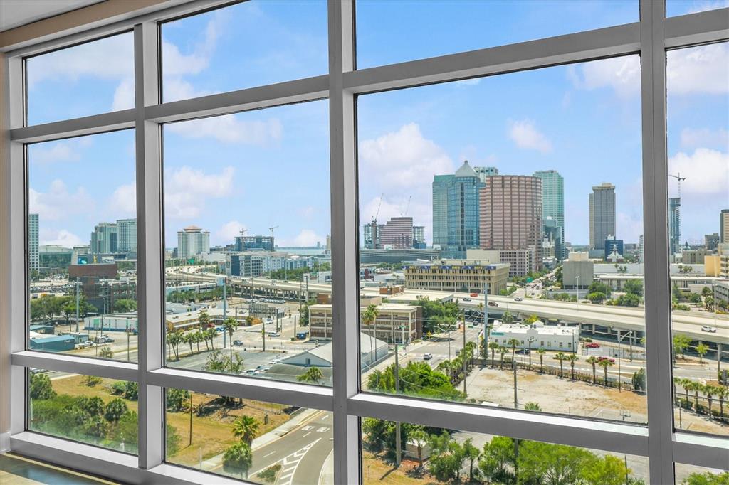 A view of the Tampa skyline through large floor-to-ceiling windows in a high-rise building — 1120 E KENNEDY BOULEVARD UNIT 1216, TAMPA, FL