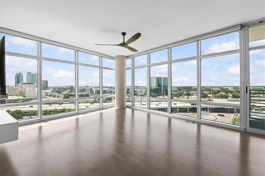 An empty room with hardwood floors, a ceiling fan, and floor-to-ceiling windows overlooking a city — 1120 E KENNEDY BOULEVARD UNIT 1216, TAMPA, FL