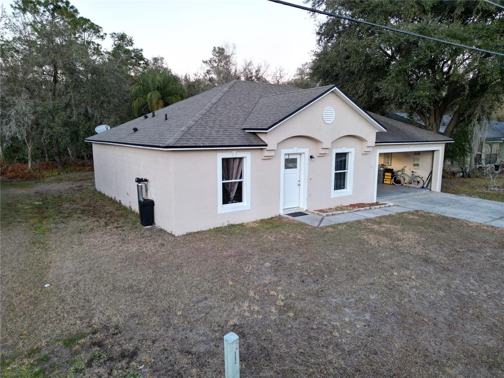 A single-story house with a beige stucco exterior, a shingled roof, and an attached garage — 796 DEL PRADO DRIVE, KISSIMMEE, FL