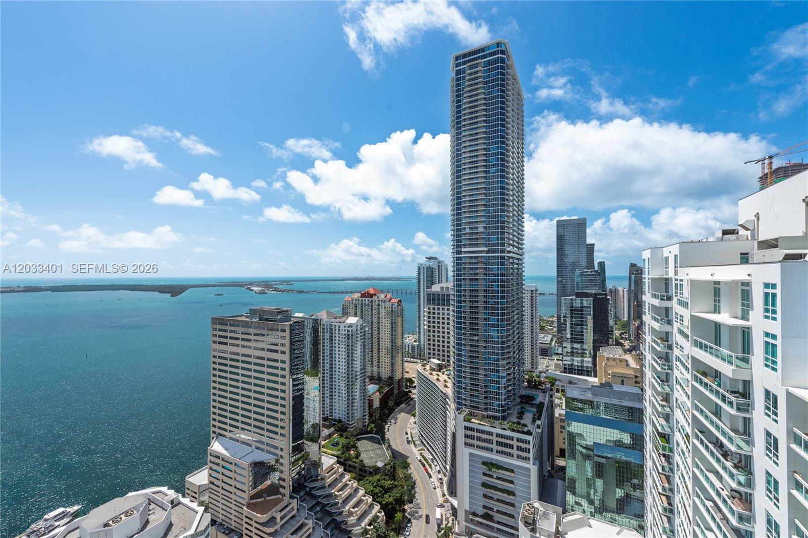 An elevated exterior view shows a dense city skyline featuring tall skyscrapers overlooking the ocean — 950 Brickell Bay Dr # 4403, Miami FL 33131, MIAMI, FL