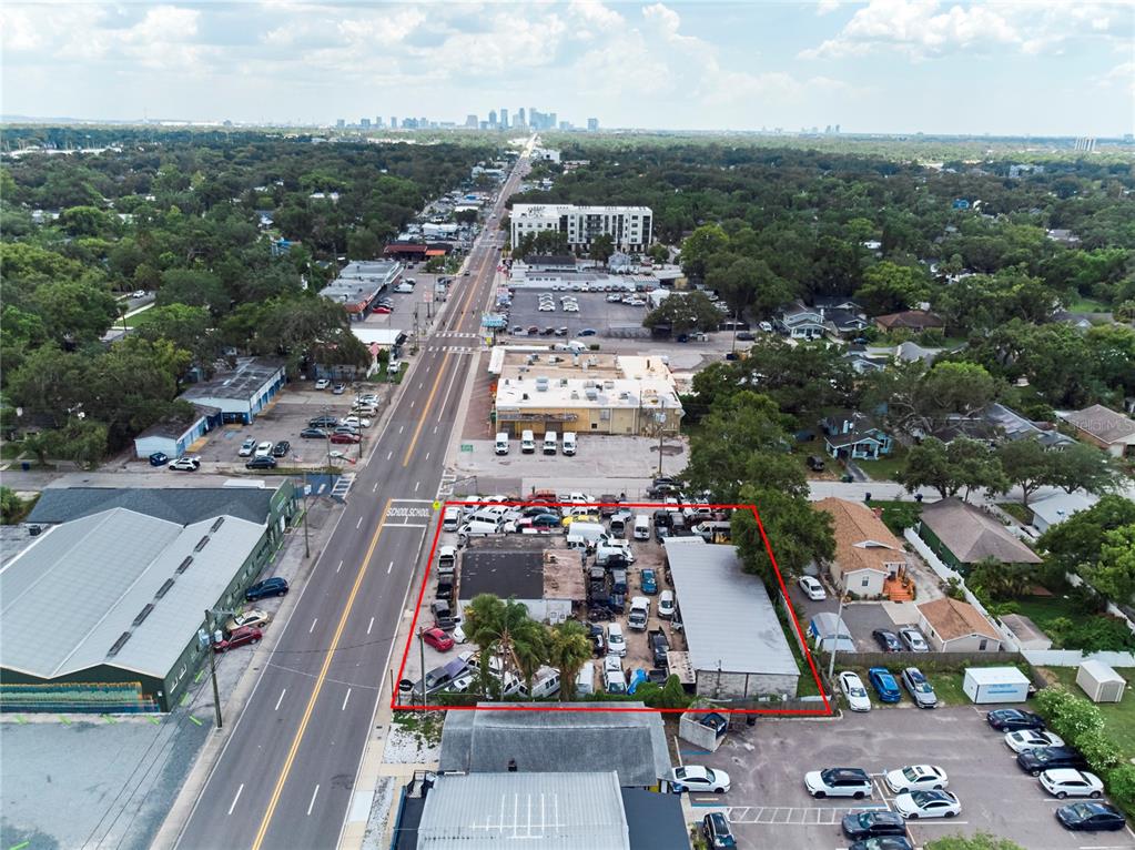 An aerial view shows a fenced-in commercial lot filled with vehicles next to a road — 6304 N FLORIDA AVENUE, TAMPA, FL